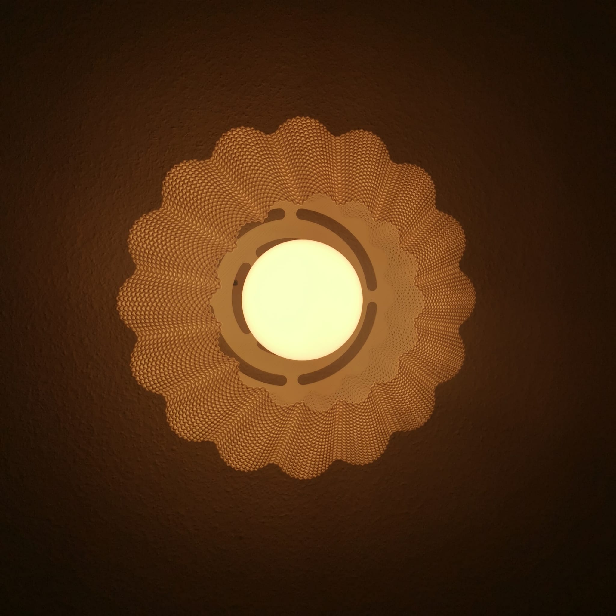 Decorative wall light fixture with a warm glow on a dark background