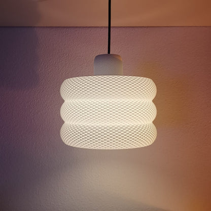 Textured pendant light hanging against a neutral wall