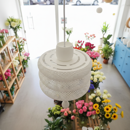 White pendant lamp with a detailed underside in a flower shop.