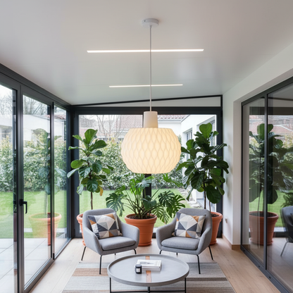 Modern living room with large windows, plants, and a stylish lamp.