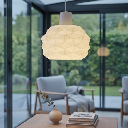 Modern geometric pendant lamp suspended above a coffee table in a minimalist living room with large windows.
