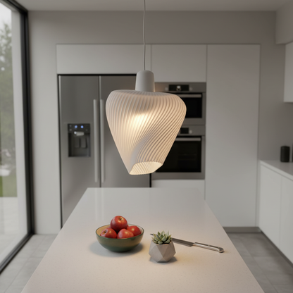 Twisted modern pendant light suspended over a white kitchen island with apples and minimalist decor.