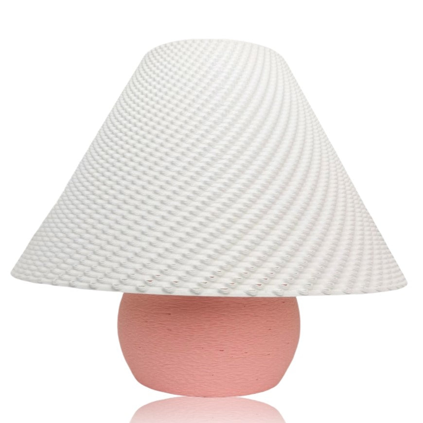 Lamp with textured white shade and pink base on a white background