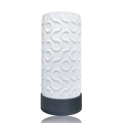 White textured cylindrical table lamp with a black base on a white background
