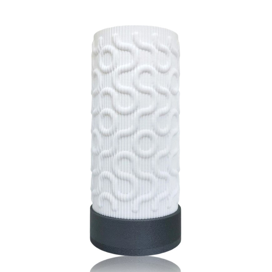 White textured cylindrical table lamp with a black base on a white background
