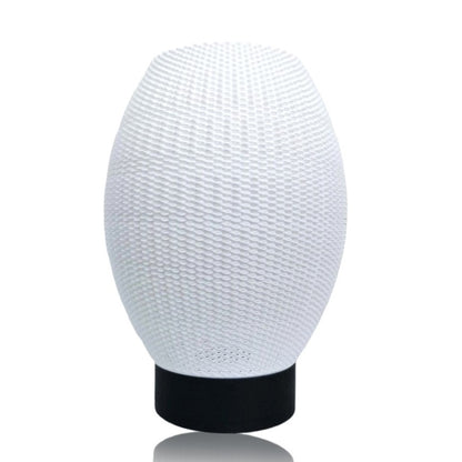 White textured lampshade on a black base against a white background