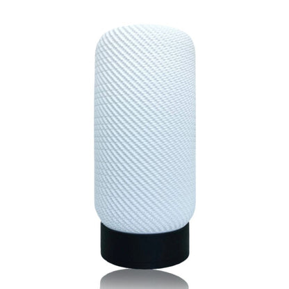 Textured white lamp with black base on a white background