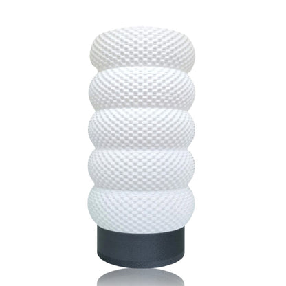 White textured cylindrical table lamp with a black base on a white background