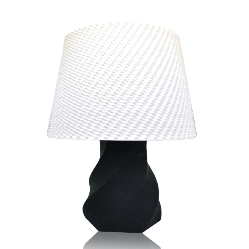 Table lamp with a black base and white textured shade on a white background