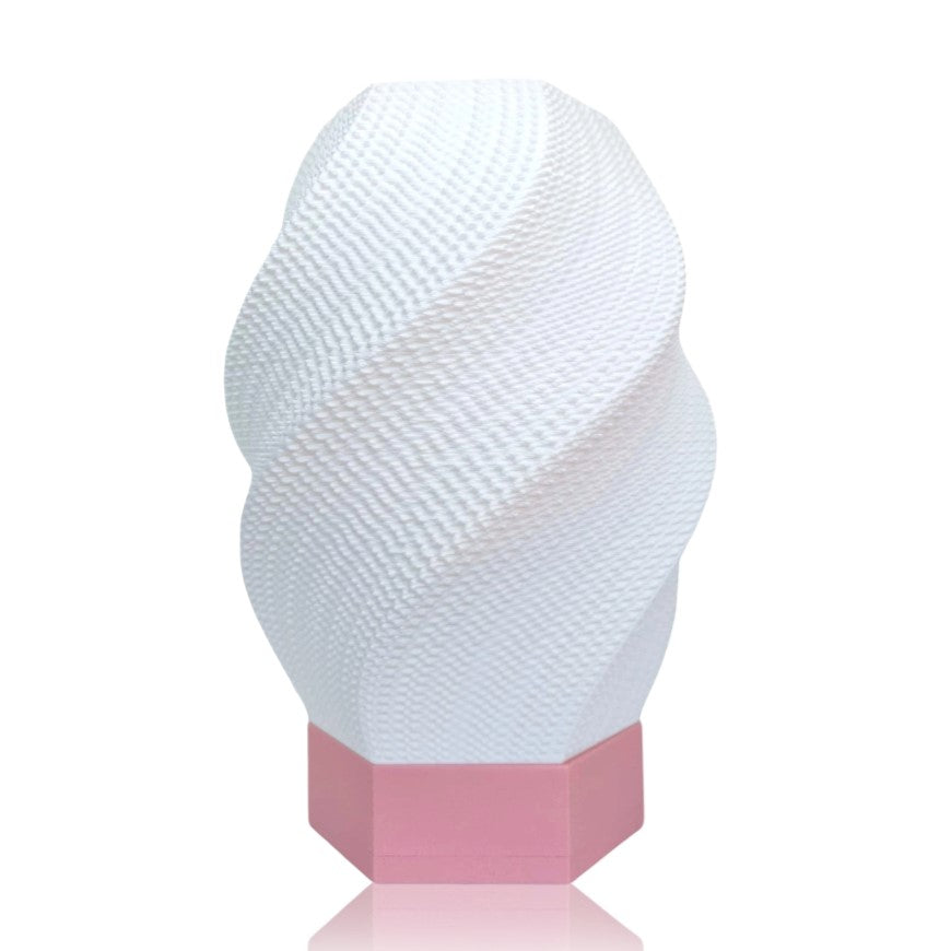 White textured table lamp on a pink base against a white background
