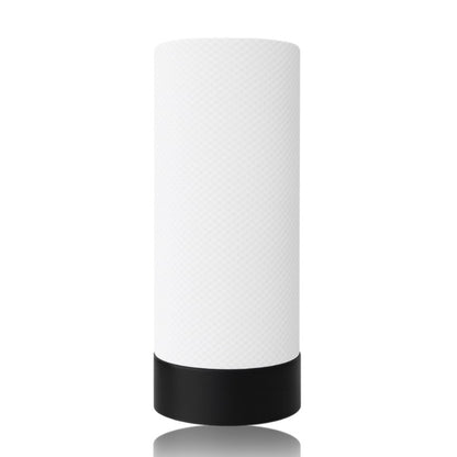 White cylindrical table lamp with black base on a white background