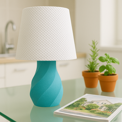 Turquoise lamp with white shade on a glass table in a room with plants and a magazine.