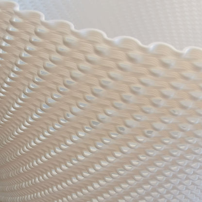 Textured beige surface with wavy pattern on a light gray background