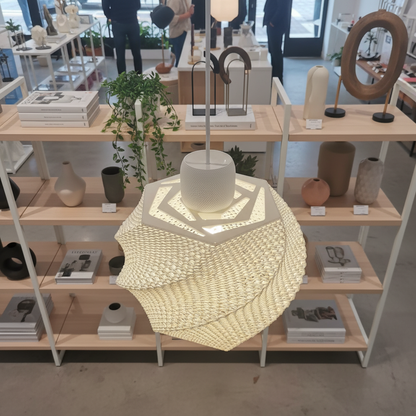 Decorative lamp on a wooden shelf with other home decor items in a store setting